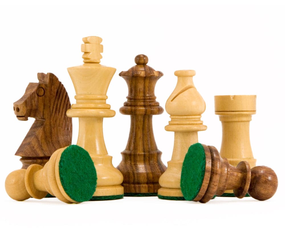 Staunton chess pieces on white background showcasing walnut and Sheesham wood grains with green felt bases.