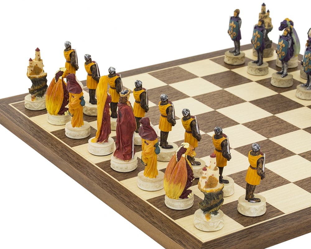 Medieval hand painted chess set with detailed Italian craftsmanship and colorful pieces on a Spanish board.