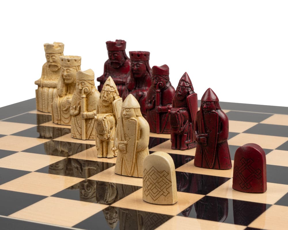 Isle of Lewis black and red chess set on a chessboard with red and cream chess pieces