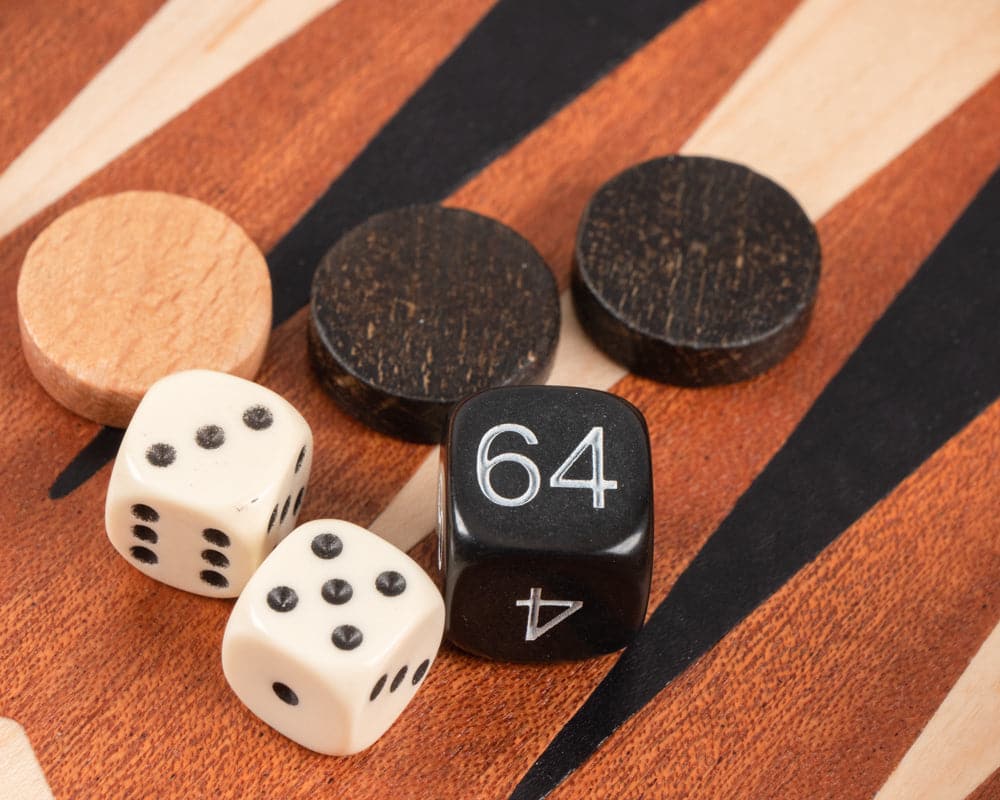 Close-up of dice and playing pieces from a Mahogany Combination Backgammon and Chess Set, showcasing deluxe Philos cups and travel size board.